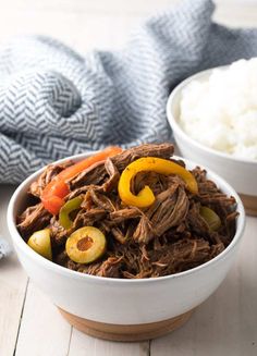 a white bowl filled with shredded beef and vegetables