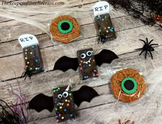 some donuts with sprinkles and bats on them sitting on a table