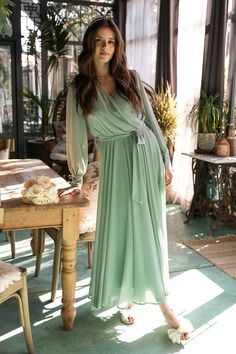 The Andie Dress in Sage is a must-have for your next special event. This maxi dress features a soft green base with a flattering faux wrap bodice and elastic waist for a perfect fit. The functional pockets and lined bodice and skirt add practicality, while the fabric's stretch makes it suitable for both maternity and nursing. With a v neckline and long, unlined sleeves, this dress is versatile AND chic. An amazing option for both bridesmaids and wedding guests. Nursing Dress For Wedding, Modest Dresses For Church, Lds Fashion, Pregnant Bridesmaid, Dresses For Church, Expensive Fashion, Ivy City Co, Green Wedding Dresses, Long Green Dress