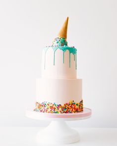 a cake with sprinkles and an ice cream cone on top