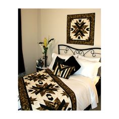 a bed with white and black quilts on it's headboard next to a window