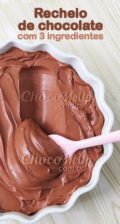 a chocolate cake in a white bowl with a pink spoon on the side that says receio de chocolate com 3 ingredientes