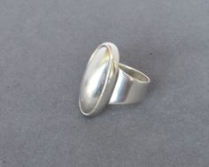 "This unique oval shaped vintage Sterling Silver Ring is large measuring 1 1/4 inches by 3/4 inches. It is artisan made as revealed in its being stamped as \"925\", \"CTI\" and \"Mexico\". It is in very good vintage condition. It is size 6 3/4 but can be readily adjusted without compromising the beauty of its very modernist design. All of our jewelry pieces are sent with \"tracking\" in an attractive gift box and safely mailed in a bubble wrap lined envelope. We ship to most International Locati Silver Oval Cabochon Signet Ring, Vintage Oval Dome Ring With Polished Finish, Classic Oval Dome Ring Stamped 925, Classic Silver Oval Dome Ring, Antique Oval Sterling Silver Signet Ring, Antique Silver Oval Signet Ring, Oval Silver Signet Ring With Cabochon, Vintage Dome Ring With Polished Oval Cabochon, Vintage Dome Ring With Oval Cabochon Polished Finish