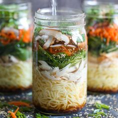 three mason jars filled with noodles and vegetables