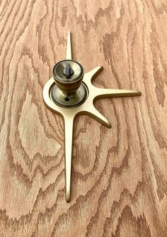 a wooden table with a metal object on it's top and wood grained surface