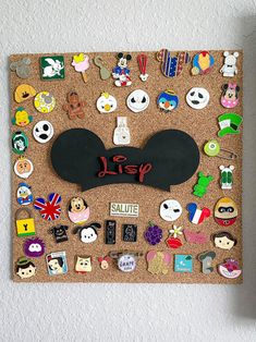 a cork board with mickey mouse's head and other disney character pins on it