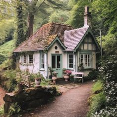 a small white house sitting in the middle of a forest