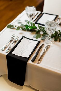 the table is set with silverware and place settings