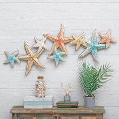 there are five starfishs hanging on the wall next to a table with books