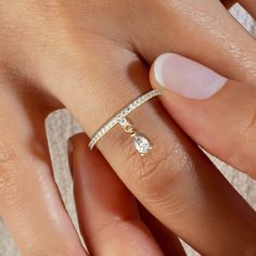 This gorgeous half diamond band boasts a single dangling diamond at its center, adding a touch of elegance to any look. Perfect for stacking with other rings or wearing alone, this delicate and versatile piece will quickly become a staple in your jewelry collection. Ideal for any occasion, this stunning ring is the perfect way to add a touch of sophistication to your style. Each piece is accompanied by an Azalea Certification and Warranty card. Please message us if you don't receive your certifi Dainty Diamond Teardrop Rings, Dainty Teardrop Diamond Rings, Teardrop Cubic Zirconia Promise Jewelry, Dangle Single Diamond Jewelry For Anniversary, Single Diamond Dangle Anniversary Jewelry, Diamond White Teardrop Promise Ring, Dangle Rings, Charm Ring, Gold Diamond Jewelry