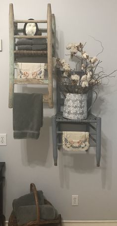 an old wooden ladder is hanging on the wall next to a basket with flowers in it