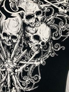 the back of a black vest with skulls on it and two crossed swords in front of them