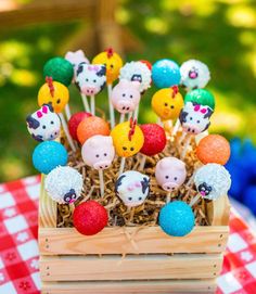 a basket filled with cake pops covered in animals