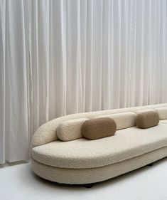 a white couch sitting in front of a curtain