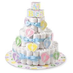 a baby shower cake made out of diapers on top of a plate with blue ribbon