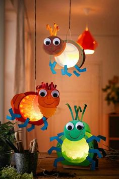 three colorful lights hanging from the ceiling in front of a plant and potted plant