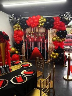 a black and gold themed party with balloons, streamers, table cloths and chairs