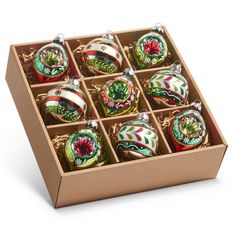 twelve christmas ornaments in a box on a white background