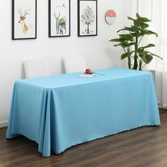 a blue table cloth with scalloped edges sits in front of three framed pictures