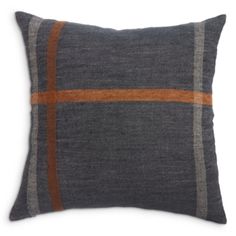 a gray and orange pillow with an orange stripe on the front, sitting on a white surface