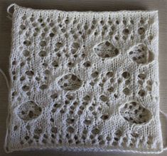 a white crocheted square with holes in it