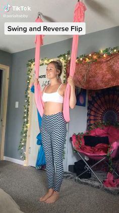 a woman is standing on a swing in her living room with the caption saying swinging and reverse flip