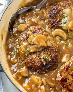 meat and mushroom stew in a skillet with a ladle on the side, ready to be eaten