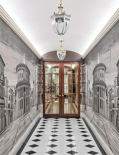 the hallway is decorated in black and white tiles with an intricate design on the wall