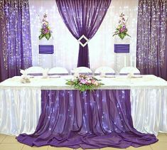 the table is set with purple and white decorations