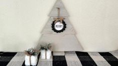 a small wooden christmas tree on top of a black and white checkered table cloth