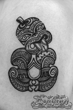 a black and white tattoo design on the back of a woman's shoulder