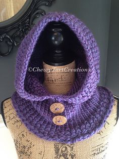 a mannequin wearing a purple knitted cowl with a button on it