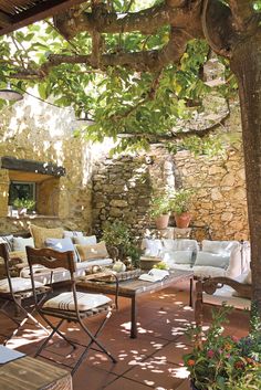 an outdoor living area with chairs and tables