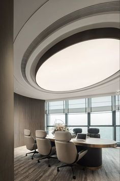 a conference room with round table and chairs in front of large window overlooking the ocean