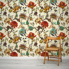 a wooden chair sitting in front of a wall with a floral pattern on it's side