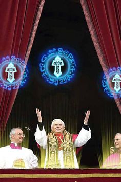 pope benedict waves to the crowd as he is presented at an event in front of red curtains