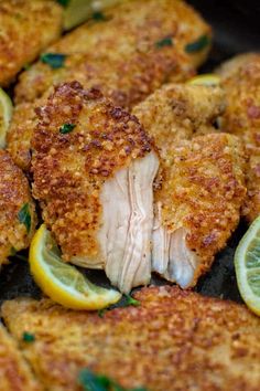 fried chicken with lemons and parsley in a skillet