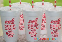 four plastic cups with straws in them sitting on a wooden table outside, and the words keep calm and boil on