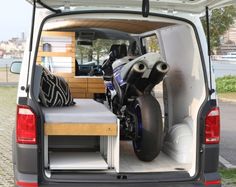 the back end of a van with a motorcycle in it's cargo area,