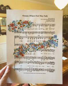 someone holding up a sheet of music with flowers all over it and the words oceans where feet may fail