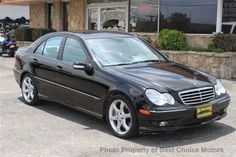 a black mercedes benz parked in front of a building