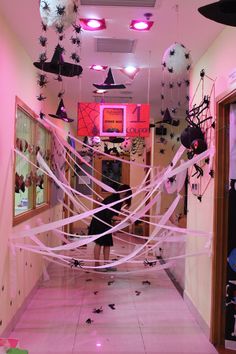 a hallway decorated in pink and black with halloween decorations hanging from it's ceiling