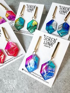 These irregular hexagonal dangle earrings showcase alcohol ink art, personally hand-drawn by me. They feature a vibrant mix of colours, accented with golden ink and a touch of glitter for a dazzling effect. The hexagonal pendants are paired with stainless steel rectangular bars, creating a striking contrast with their simple, clean lines. As wearable art and completely handmade, each piece is truly unique. Earrings are backed with in gold plated 304 stainless steel and butterfly back. Handmade i Trendy Hand Painted Jewelry Gift, Colorful Drop Earrings As A Gift, Colorful Artsy Earrings For Gift, Alcohol Ink Earrings, Alcohol Ink Jewelry, Alcohol Ink Art, Jewellery Handmade, Jewelry Card, Earrings Small