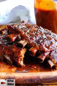 slow cooker baby back ribs on a cutting board with bbq sauce in the background