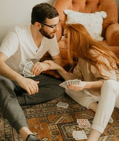 a man and woman playing cards on the floor