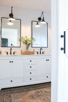 a white bathroom with double sinks and mirrors