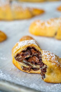 chocolate filled pastries on a baking sheet with powdered sugar