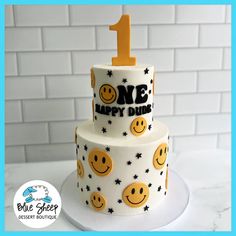 a birthday cake decorated with smiley faces and the number one on it's side