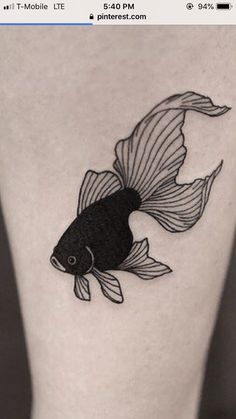 a black and white fish tattoo on the leg