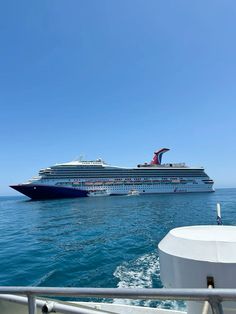 a large cruise ship in the middle of the ocean with another boat behind it on the water